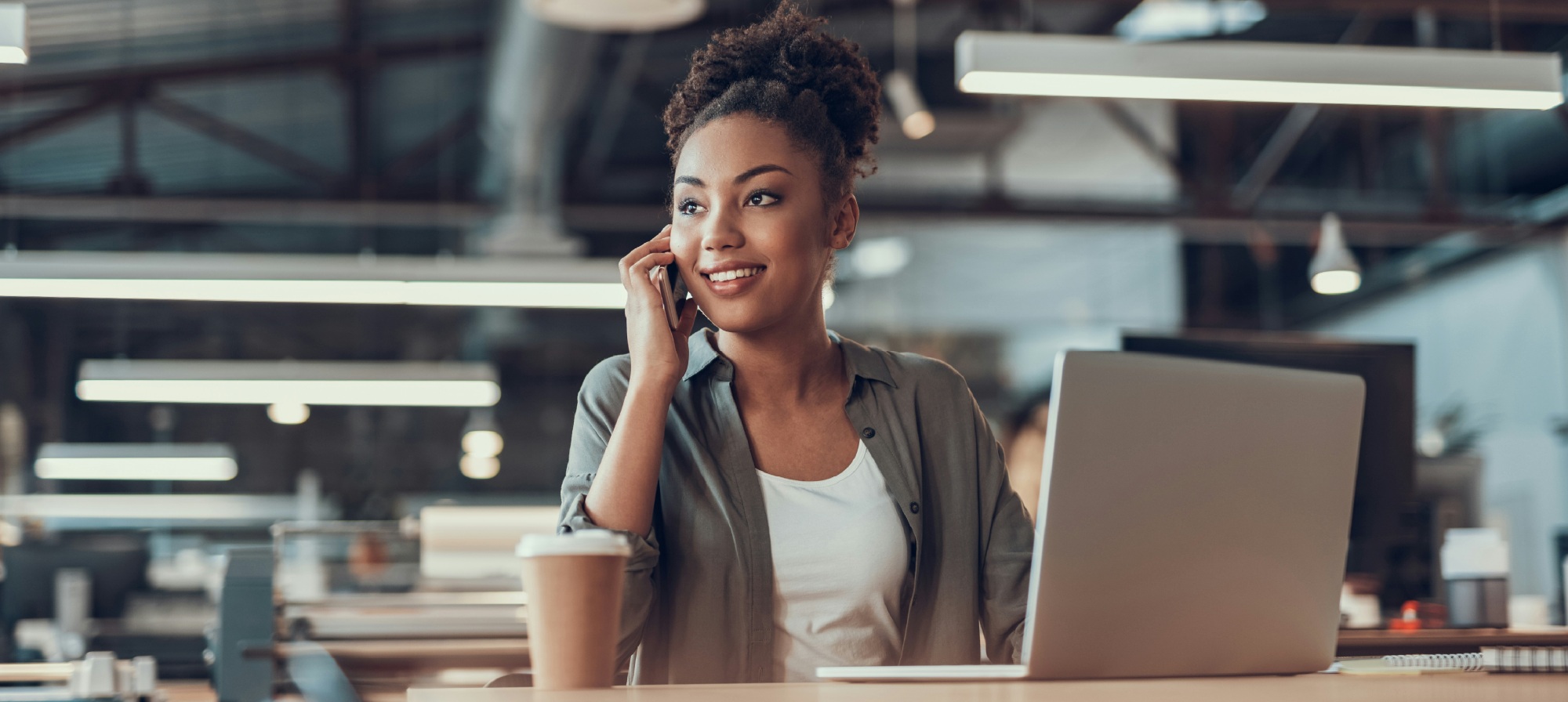 Business woman at desk with coffee and laptop